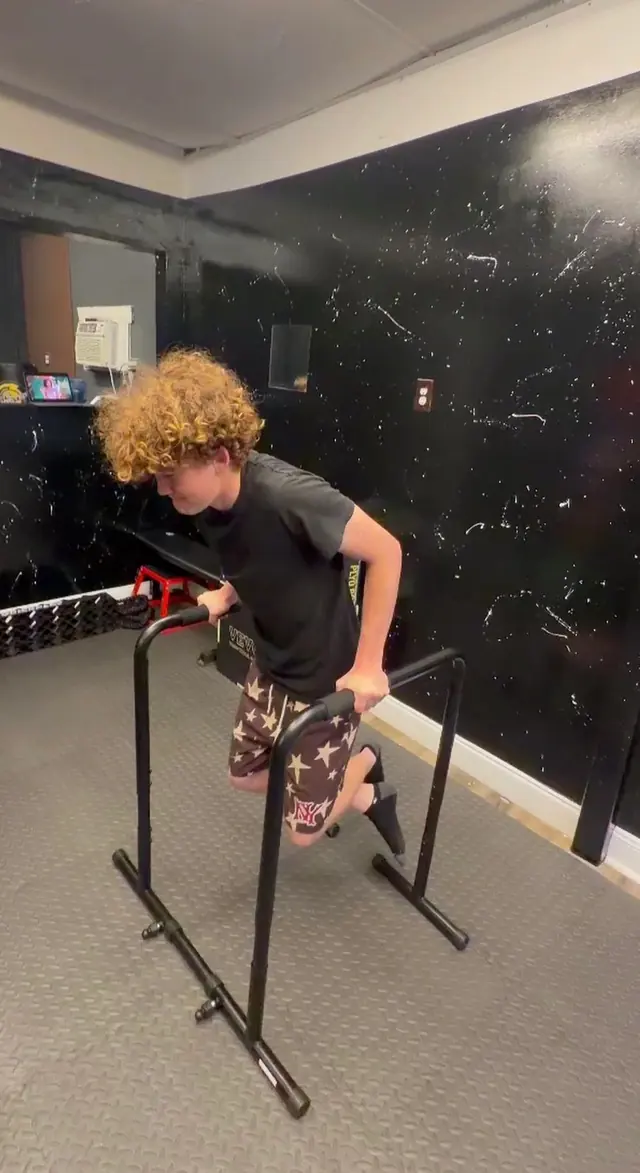 Young athlete working through dips on a dip station