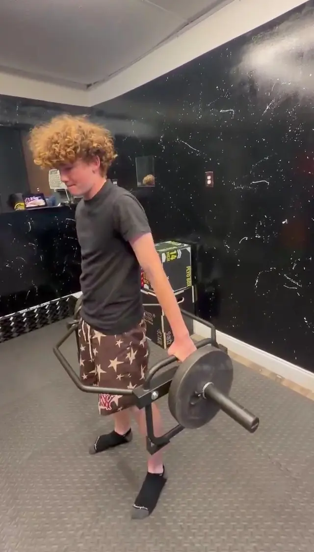 Young athlete lifting a trap bar with coaching on technique